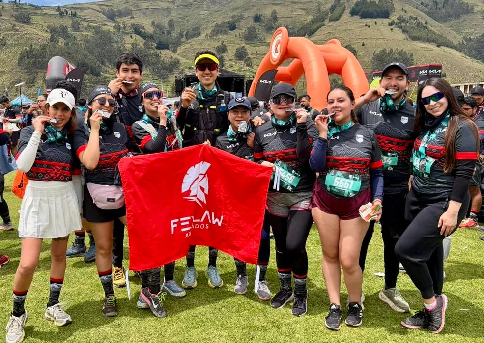 Equipo de Fexlaw con sus medallas y la bandera en una carrera de montaña