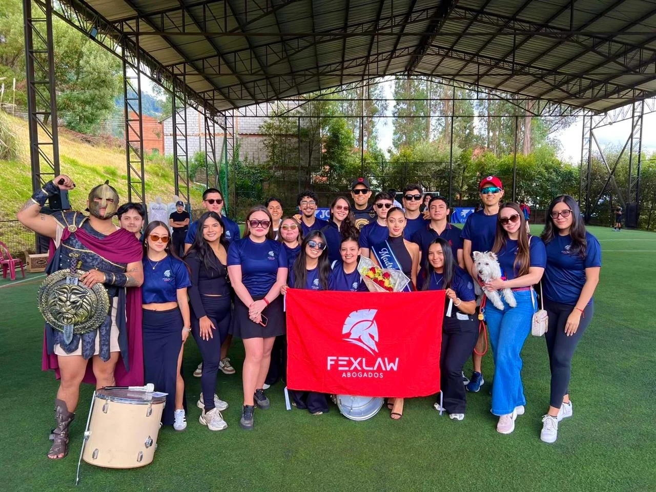 Equipo de Fexlaw con su bandera y el espartano en un evento deportivo