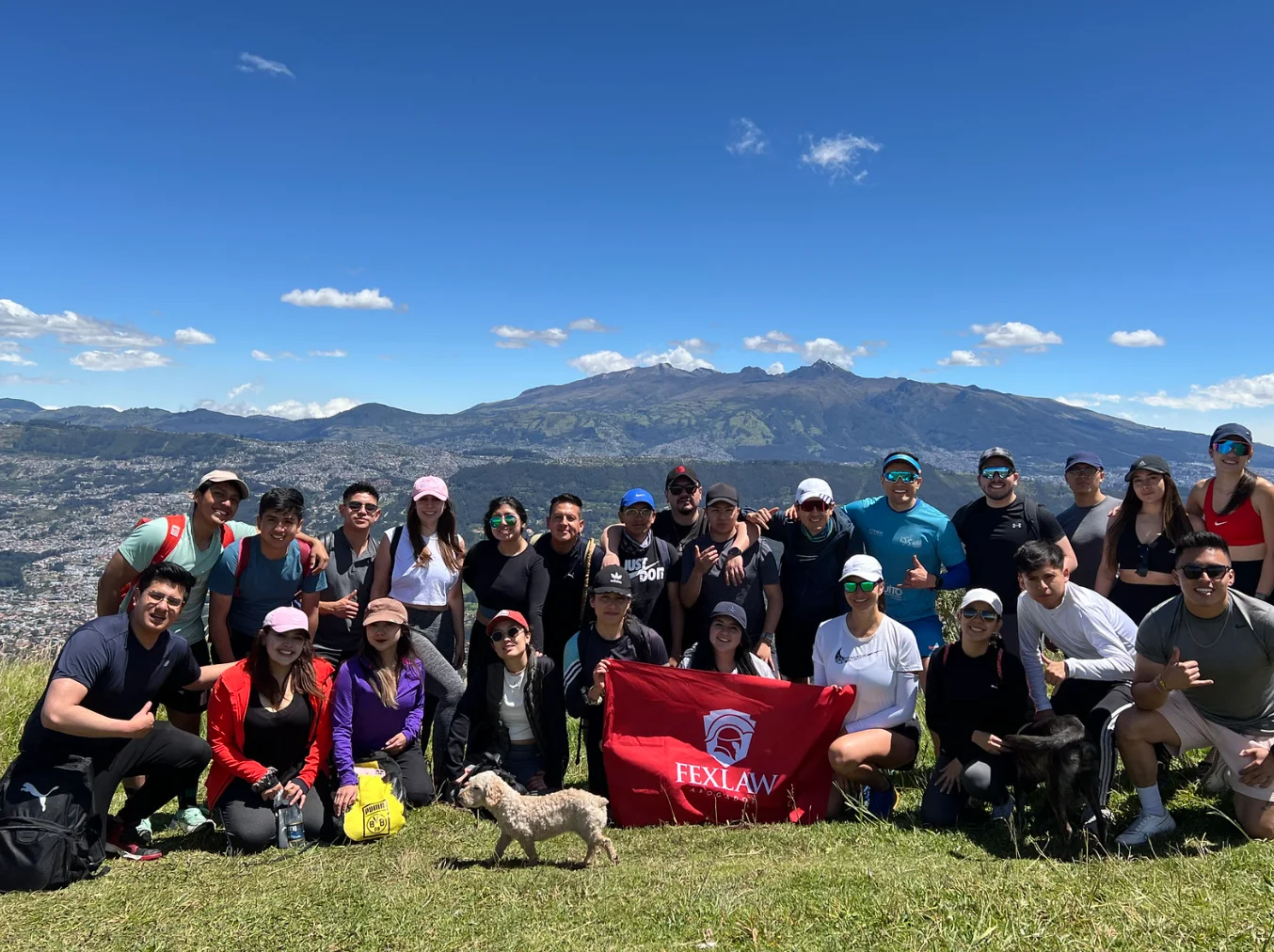 Equipo de Fexlaw con su bandera en la cima de una montaña sobre Quito