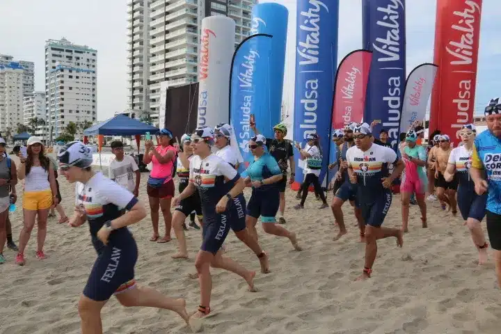 Integrantes de Fexlaw corriendo hacia el mar en la partida de un triatlón